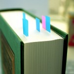 A photograph of a book with post it flags stuck in its pages.